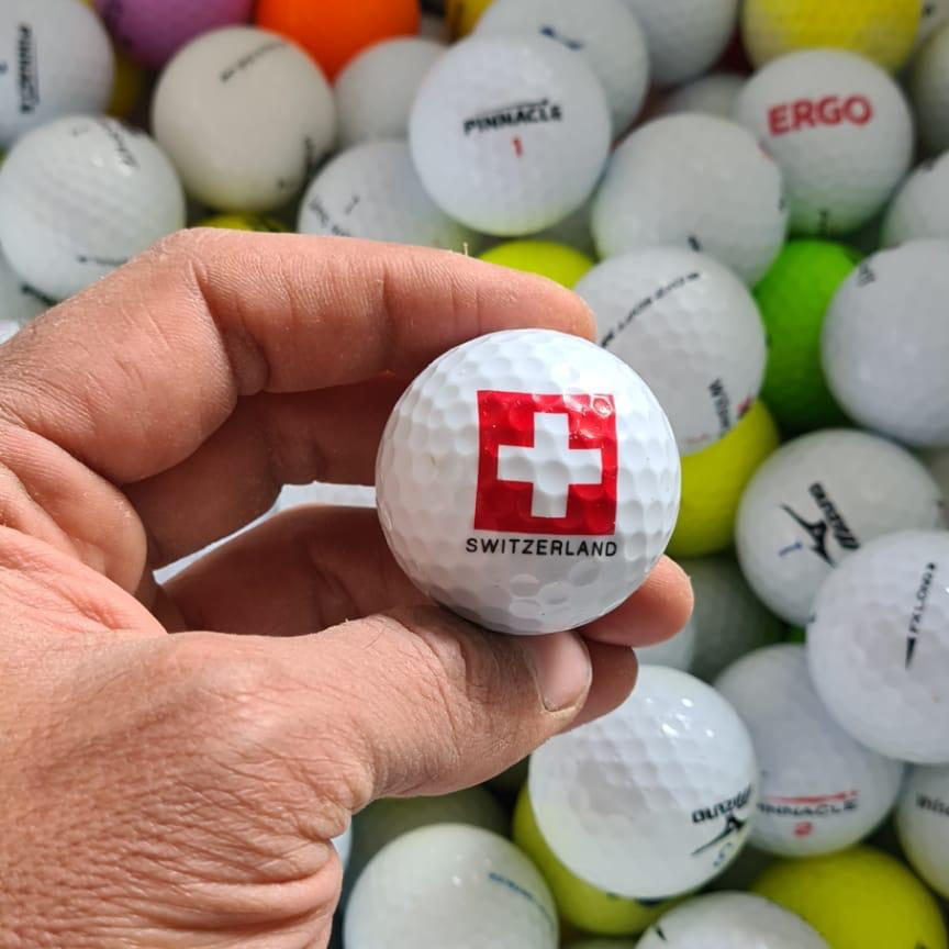 ⛳ Golfball mit Schweizer Kreuz in der Hand vor vielen Lakeballs – TopBall, Golfbälle mit Erfahrung aus der Schweiz